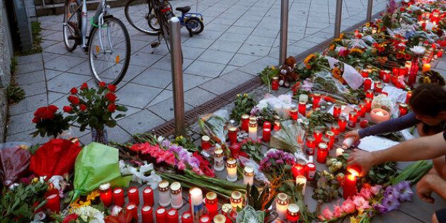 People light candles beside flowers laid in front of the Olympia shopping mall, where yesterday's shooting rampage started, in Munich, Germany July 23, 2016. REUTERS/Arnd Wiegmann