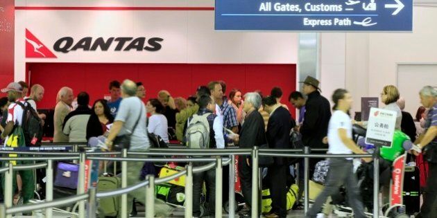 Travelers gather at the Qantas sales desk at Sydney Airport in Sydney, Saturday, Oct. 29, 2011. Qantas Airways grounded its global fleet indefinitely and locked out workers Saturday after weeks of disruptive strikes, and the disappointed Australian government was seeking emergency arbitration. (AP Photo/Rick Rycroft)