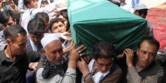 Afghan Shiites carry the coffin of a victim killed when a suicide attacker detonated explosive belts at a mass demonstration over the weekend.