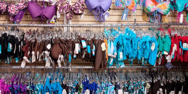 A lot of bathing suits hang on wall at swim wear store