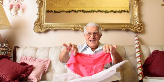 Senior man holding up pink panties