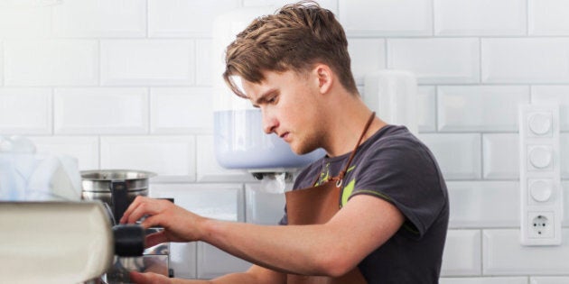 Barista making coffee using espresso machine at restaurant