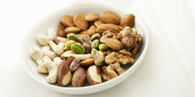 White bowl containing a variety of nuts, close up