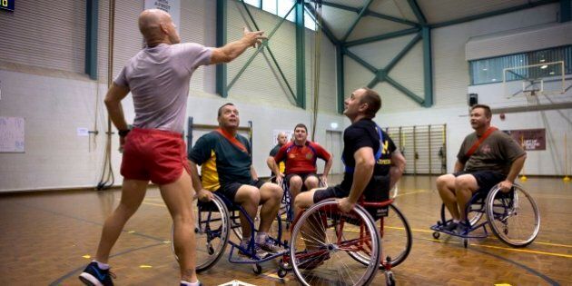 DARWIN, AUSTRALIA - APRIL 15: In this handout photo provided by the Australian Defence Force, Australian Army physical training instructor Corporal Todd Hayes tosses the ball into play during a game of wheelchair AFL attended by Prince Harry at the Soldier Recover Centre, Robertson Barracks on April 15, 2015 in Darwin, Australia. Prince Harry has spent his first two weeks secondment in the Australian Army with the North-West Mobile Force (NORFORCE) and the 1st Brigade. (Photo by CPL Oliver Carter/Australian Defence Force via Getty Images)