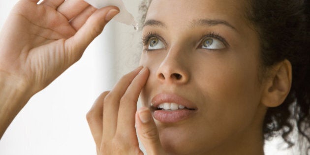 Young woman putting eye drops