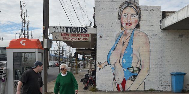Pedestrians walk past a mural of Democratic presidential nominee Hillary Clinton clad in a skimpy swimsuit.