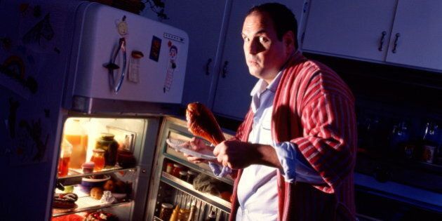 Man looking shocked, taking food out of refrigerator at night