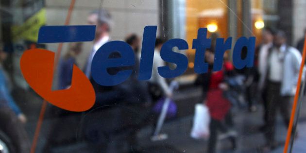 Business people walk through the foyer of Telstra Corp.'s head office in Sydney, Australia, Thursday, Aug. 9, 2012. Australia's largest telecommunications company reported a 5.4 percent increase in annual profit amid a boost in new mobile phone customers. (AP Photo/Rob Griffith)