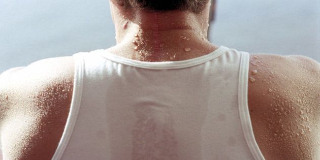 Man in white vest covered in sweat, rear view, close-up