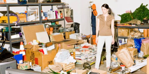 Frustrated woman looking at clutter in garage