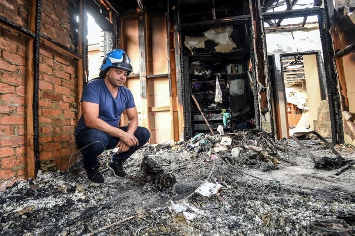 Ash Ibraheim with a burnt out hoverboard in his daughter's bedroom in Strathmore, following a fire.