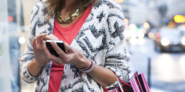 Woman using smartphone while shopping