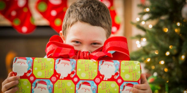 Caucasian boy holding Christmas gift