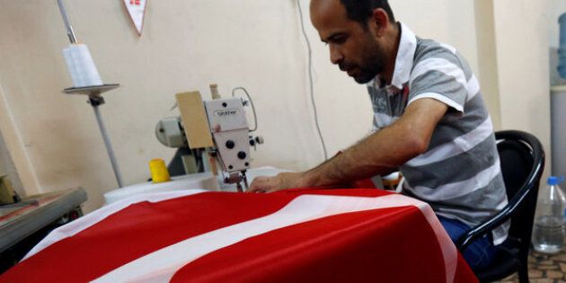 A worker makes Turkish flags at a small flag factory in Istanbul, Turkey, July 20, 2016. REUTERS/Murad Sezer