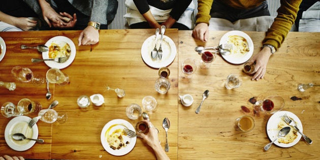 Overhead view of group of friends finishing dessert at table in restaurant