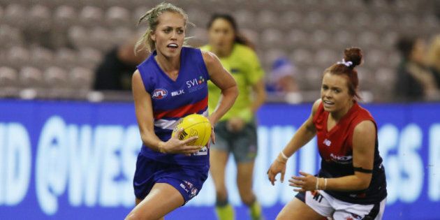 MELBOURNE, AUSTRALIA - AUGUST 16: Kaitlyn Ashmore of the Bulldogs runs with the ball away from Brianna Green of the Demons during a Women's AFL exhibition match between Western Bulldogs and Melbourne at Etihad Stadium on August 16, 2015 in Melbourne, Australia. (Photo by Michael Dodge/Getty Images)
