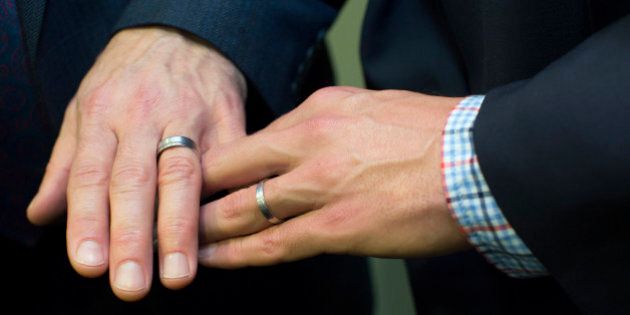 Men's hands together showing wedding rings