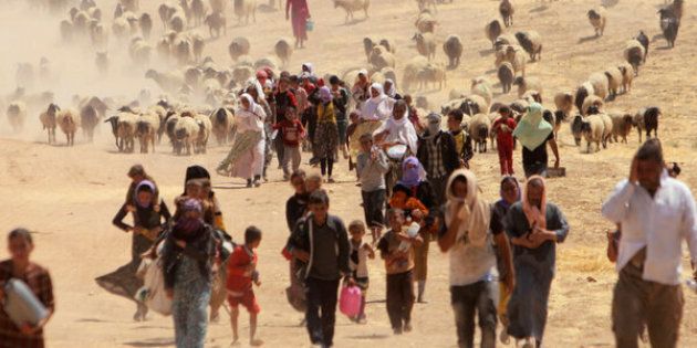 Displaced people from the minority Yazidi sect, fleeing violence from forces loyal to the Islamic State in Sinjar town, walk towards the Syrian border, on the outskirts of Sinjar mountain, near the Syrian border town of Elierbeh of Al-Hasakah Governorate August 10, 2014. REUTERS/Rodi Said/File Photo