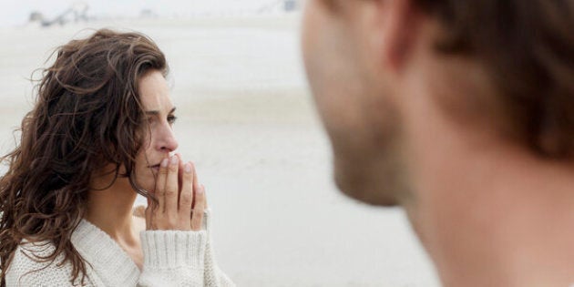 Serious brunette woman and man on the beach