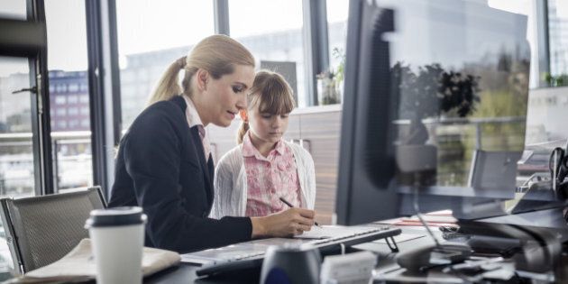 A modern working woman is visited by her daughter at work Horizontal shot.