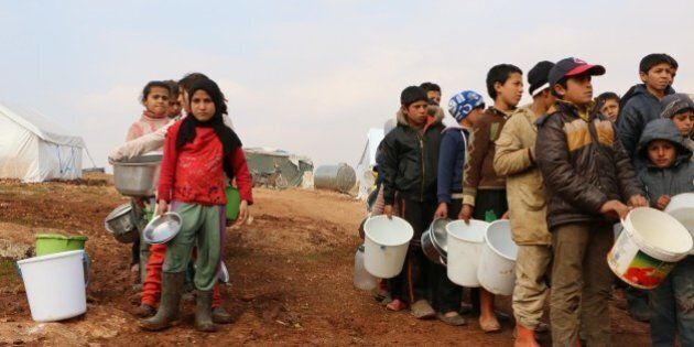 ALEPPO, SYRIA - JANUARY 31: Turkmen children carry wait for food distribution at al-Ra'ee camp, southern Aleppo in Syria on January 31, 2016. Turkmen who fled their homes following attacks by Syrian and Russian forces, live under harsh conditions at al-Ra'ee camp. (Photo by Mustafa Sultan/Anadolu Agency/Getty Images)