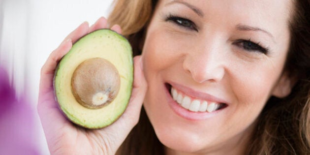 USA, New Jersey, Jersey City, Portrait of woman holding avocado