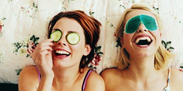 Two Female Teenagers Lying in Bed Wearing Eye Masks