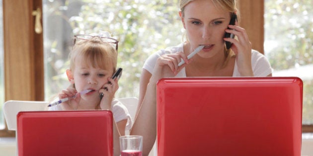 daughter copy mother working on laptop