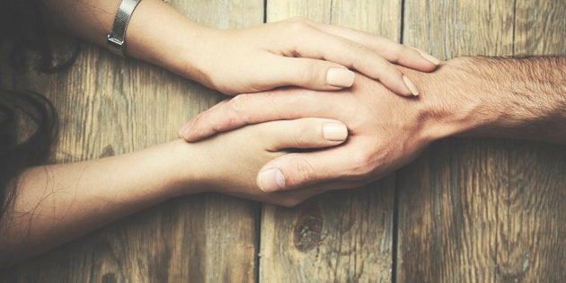 man and a woman holding hands at a wooden table