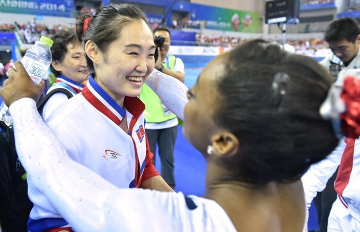 Hong Un Jong of North Korea is congratulated by U.S. gymnast Simone Biles.