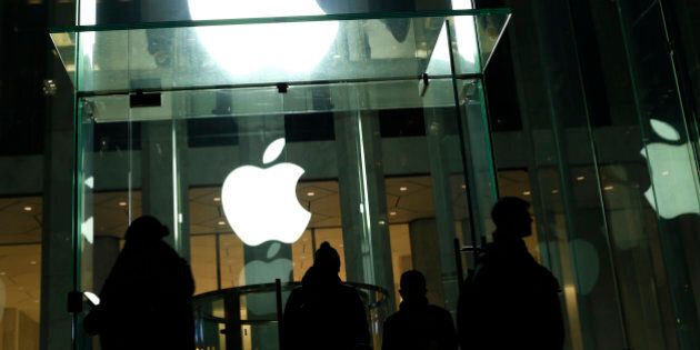 People walk outside the Apple store on the Fifth Avenue in New York on February 17, 2016.Apple's challenge of a court order to unlock an iPhone used by one of the San Bernardino killers opens up a new front in the long-running battle between technology companies and the government over encryption. / AFP / KENA BETANCUR (Photo credit should read KENA BETANCUR/AFP/Getty Images)