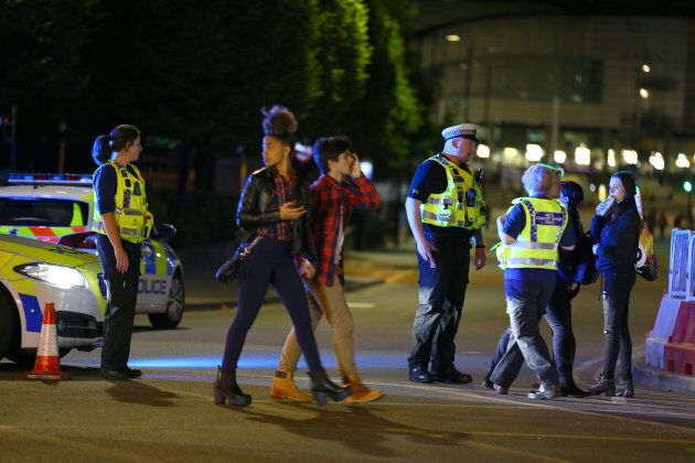 Concert-goers leave the Manchester Arena following the blast as police cordon off the area in case of further attack.