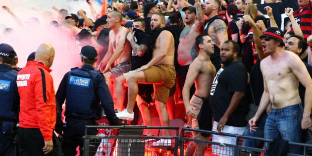 MELBOURNE, AUSTRALIA - FEBRUARY 06: Wanderers fans in the crowd let off flares as police officers look on during the round 18 A-League match between the Melbourne Victory and Western Sydney Wanderers at Etihad Stadium on February 6, 2016 in Melbourne, Australia. (Photo by Scott Barbour/Getty Images)