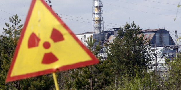 A radiation sign is seen in front of the Chernobyl Nuclear Power plant after firefighters have nearly extinguished a forest fire near Chernobyl plant, which came within about 20 kilometres (12 miles) of Chernobyl after breaking out on April 28, 2015, but officials said it posed no danger to the plant and radiation levels in the zone remained unchanged. AFP PHOTO / ANATOLII STEPANOV (Photo credit should read ANATOLII STEPANOV/AFP/Getty Images)