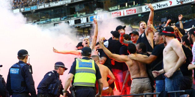 MELBOURNE, AUSTRALIA - FEBRUARY 06: Wanderers fans in the crowd let off flares as police officers look on during the round 18 A-League match between the Melbourne Victory and Western Sydney Wanderers at Etihad Stadium on February 6, 2016 in Melbourne, Australia. (Photo by Scott Barbour/Getty Images)