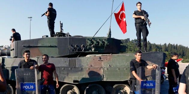 People pose with policemen after troops involved in the coup surrendered on the Bosphorus Bridge in Istanbul, Turkey July 16, 2016. REUTERS/Murad Sezer