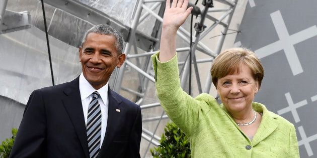 Former US president Barack Obama and Chancellor Angela Merkel arrive on stage during the Protestant church day (Kirchentag) event at the Brandenburg Gate (Brandenburger Tor) in Berlin on May 25, 2017.?Barack Obama attends a panel dicussion with Angela Merkel in Berlin before heading to Baden-Baden to receive a German media prize. / AFP PHOTO / John MACDOUGALL / ALTERNATIVE CROP (Photo credit should read JOHN MACDOUGALL/AFP/Getty Images)