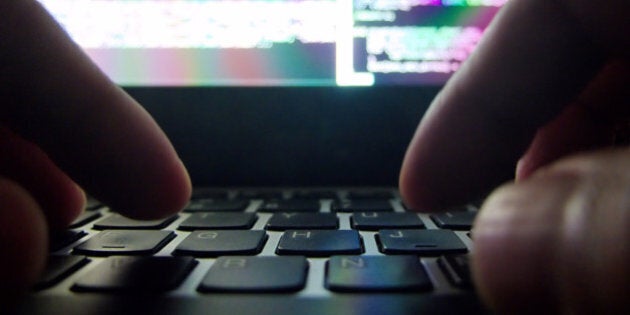Cyber Attack - this photo portraits a hacker's hands busy at work on some code in the dark. The wide angle close up view gives a unique first person perspective of the hacking activity. Focus was on the keyboard hence the colorful screen is blurred out.