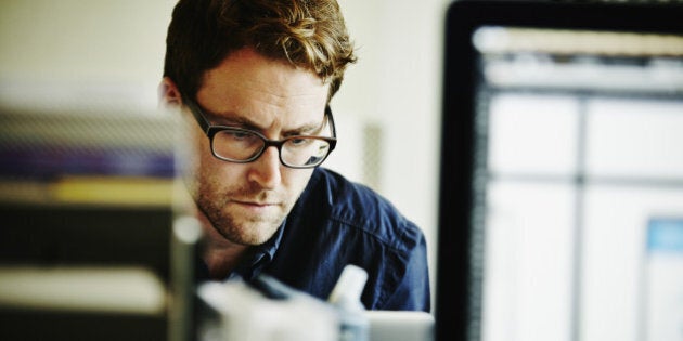 Businessman working on project on laptop in startup office