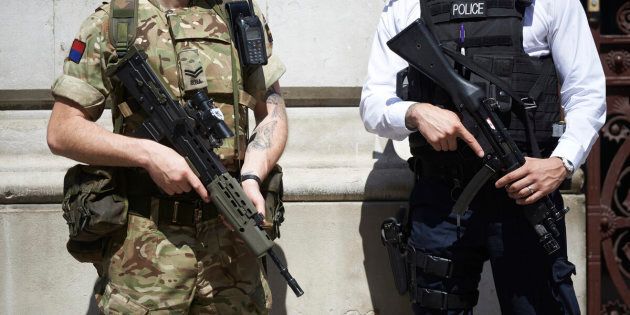 A British army soldier and police officer are stationed in London as Britain raises its terror alert following the attack in Manchester. 