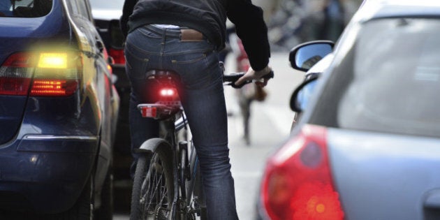 Male bicyclist in heavy traffic