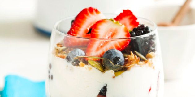Homemade granola with yogurt, fresh berry and honey.