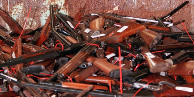 TO GO WITH US-shooting-guns-Australia,FOCUS by Martin Parry(FILES) This file photo taken on July 28, 1997 shows a policeman responsible for the collection of guns, Mick Reolandts, holding a military type shotgun, one of 4,500 guns on display before being melted down in Sydney after Australia banned all automatic and semi-automatic rifles in the aftermath of the Port Arthur shooting in 1996. When Martin Bryant massacred 35 people with semi-automatic weapons at Port Arthur in 1996, then-Australian prime minister John Howard reacted swiftly by pushing for tough new national gun laws. Within a year gun licences had been tightened, a weapons buy-back was enacted and an amnesty launched for anyone holding illegal arms, moves that took more than 600,000 guns out of action. AFP PHOTO / FILES / WILLIAM WEST (Photo credit should read WILLIAM WEST/AFP/Getty Images)