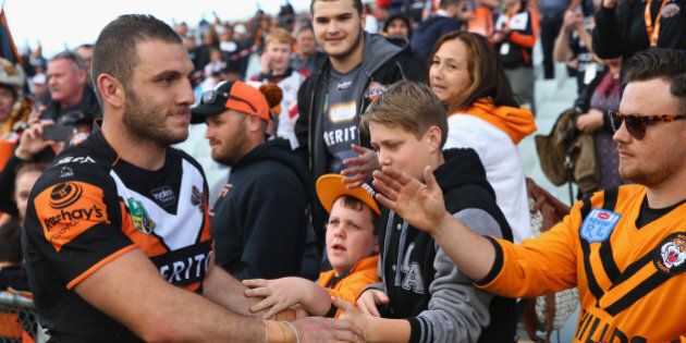 SYDNEY, AUSTRALIA - AUGUST 30: Robbie Farah of the Wests Tigers high fives the crowd after the Tigers last home game of the season during the round 25 NRL match between the Wests Tigers and the New Zealand Warriors at Campbelltown Sports Stadium on August 30, 2015 in Sydney, Australia. (Photo by Mark Kolbe/Getty Images)