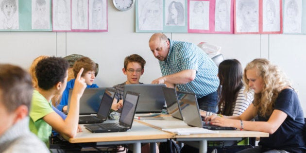 GOETTINGEN, GERMANY - SEPTEMBER 19: Posed scene: teacher supervising students who are working with laptops during a class at the Georg-Christoph-Lichtenberg-Gesamtschule IGS Goettingen on September 19, 2014, in Goettingen, Germany. The Georg-Christoph-Lichtenberg-Gesamtschule is a comprehensive school. Photo by Thomas Trutschel/Photothek via Getty Images)***Local Caption***