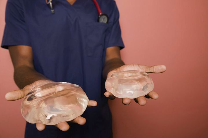 A surgeon holds a pair of implants.