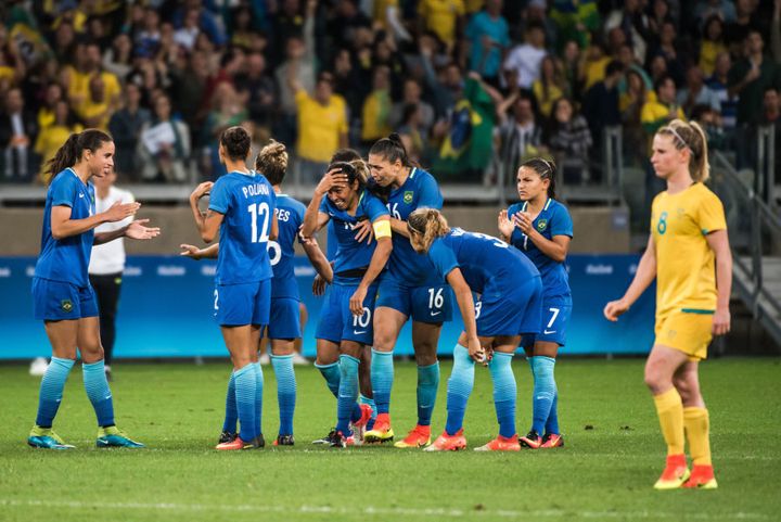 Brazilian players comfort Marta after she misses.