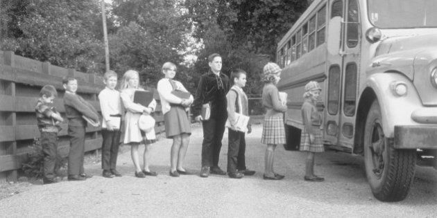 Line of children at bus stop getting on the school bus, Birmingham, Michigan, November 5, 1966. (Photo by Camerique/Getty Images)
