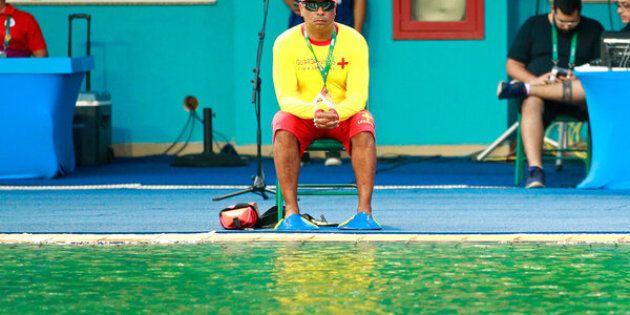 RIO DE JANEIRO, BRAZIL - AUGUST 09: A lifeguard sits by the edge of the diving pool during the Women's Diving Synchronised 10m Platform Final on Day 4 of the Rio 2016 Olympic Games at Maria Lenk Aquatics Centre on August 9, 2016 in Rio de Janeiro, Brazil. (Photo by Adam Pretty/Getty Images)