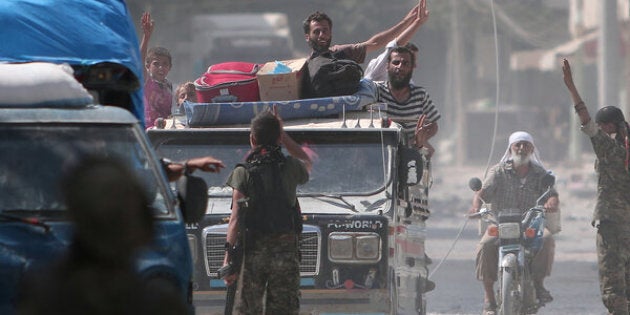 Syria Democratic Forces (SDF) fighters greet civilians who were evacuated by the SDF from an Islamic State-controlled neighbourhood of Manbij, in Aleppo Governorate, Syria, August 12, 2016. The SDF has said Islamic State was using civilians as human shields. REUTERS/Rodi Said